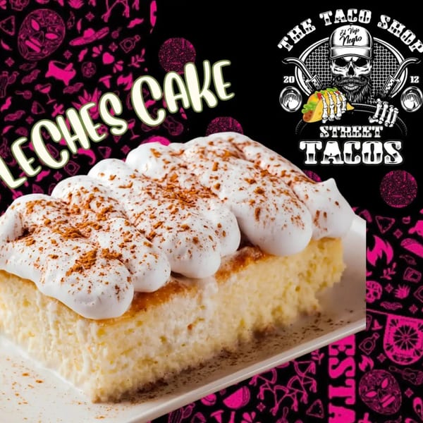 A slice of Tres Leches cake with whipped cream and cinnamon on a white plate.