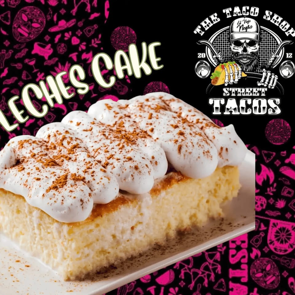 A slice of tres leches cake with whipped cream and cinnamon on a white plate.