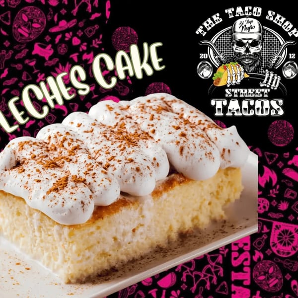 A slice of Tres Leches cake with whipped cream and cinnamon on a white plate.
